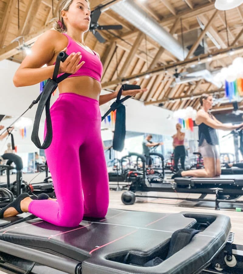 A Lagree House client in pink working out on a Lagree machine
