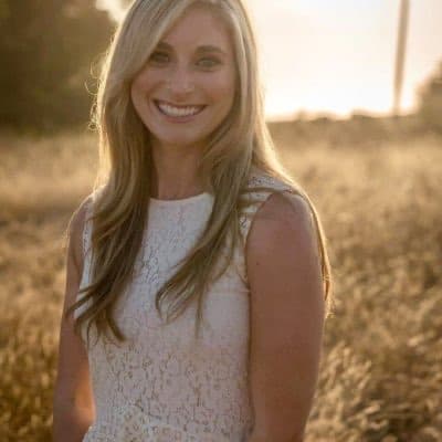 Danielle Orlick smiling in a field at sunset