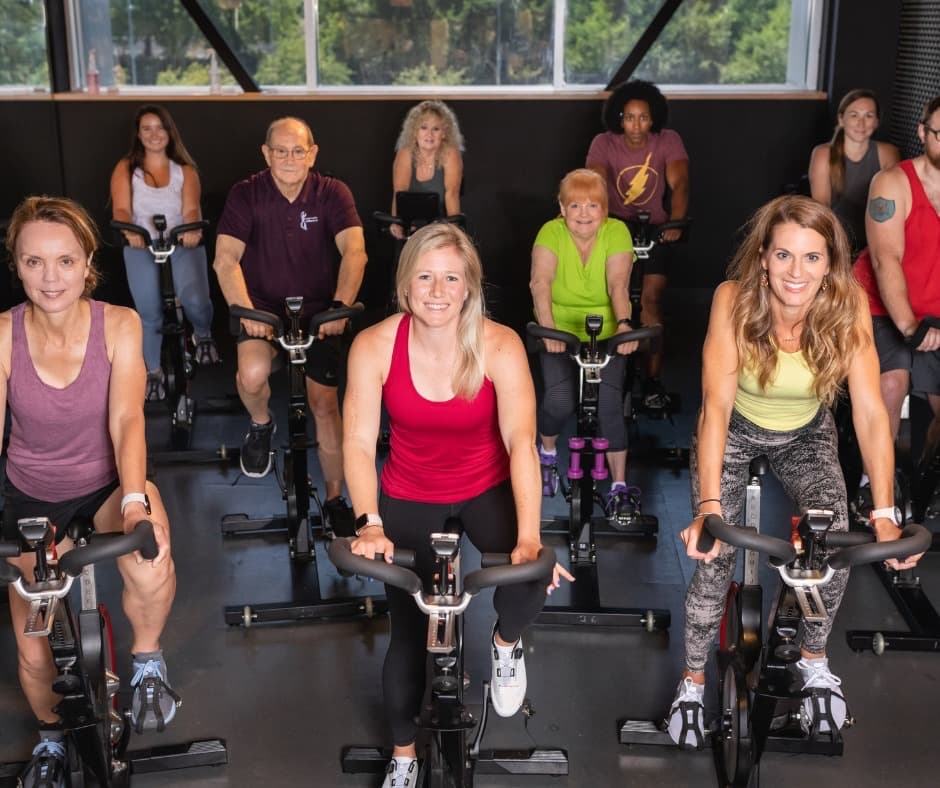 Members riding in an indoor cycling class at Milestone Wellness Center